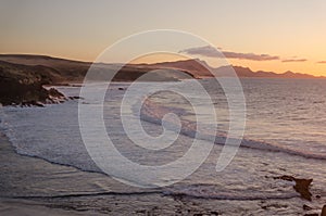 Orange sunset. ocean landscape. Rocks and wave of ocean