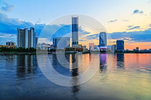 Orange sunset over the city pond and the business part of the city of Yekaterinburg