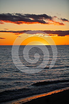 Orange sunset over horizon of lake water at dusk in the evening