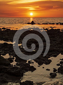 Orange sunset on sea rocky shore