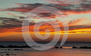 Orange sunset on sea rocky shore