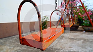 Orange swing set sitting with flowers inside the house.