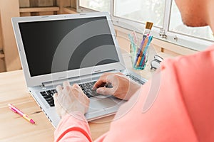 Orange T-Shirt Businessman Typing Laptop or Notebook in Home Office