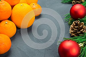 Orange and tangerine with branch christmas tree and red ball on black concrete background