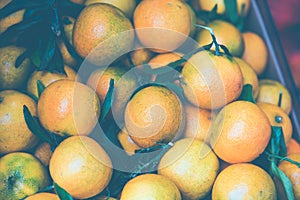 Orange tangerines mandarin in a box ourdoors market. Toned image.