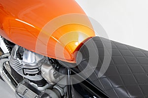 Orange tank and twin motor of a classic motorcycle detail