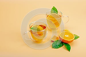 Orange tea in glass cups with ripe fruits. Refreshment seasonal drink, conceptual background