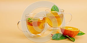 Orange tea in glass cups with ripe fruits. Refreshment seasonal drink, conceptual background