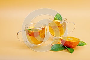 Orange tea in glass cups with ripe fruits. Refreshment seasonal drink, conceptual background