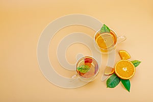 Orange tea in glass cups with ripe fruits. Refreshment seasonal drink, conceptual background