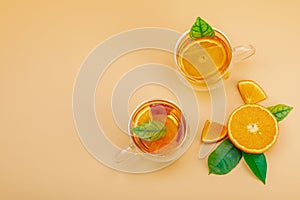 Orange tea in glass cups with ripe fruits. Refreshment seasonal drink, conceptual background