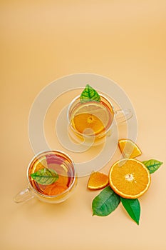 Orange tea in glass cups with ripe fruits. Refreshment seasonal drink, conceptual background