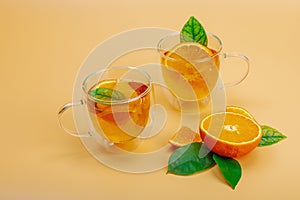 Orange tea in glass cups with ripe fruits. Refreshment seasonal drink, conceptual background