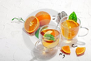 Orange tea in glass cups with ripe fruits. Refreshment seasonal drink, conceptual background