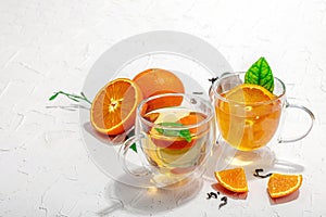 Orange tea in glass cups with ripe fruits. Refreshment seasonal drink, conceptual background