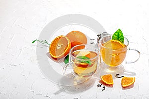 Orange tea in glass cups with ripe fruits. Refreshment seasonal drink, conceptual background