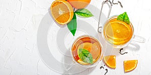 Orange tea in glass cups with ripe fruits. Refreshment seasonal drink, conceptual background