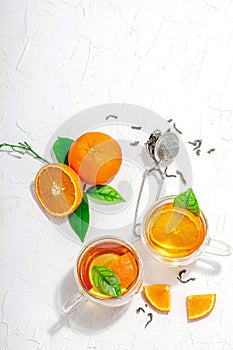 Orange tea in glass cups with ripe fruits. Refreshment seasonal drink, conceptual background