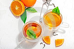 Orange tea in glass cups with ripe fruits. Refreshment seasonal drink, conceptual background