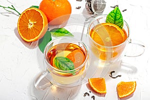 Orange tea in glass cups with ripe fruits. Refreshment seasonal drink, conceptual background