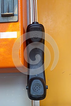 Orange telephone receiver with shawdow light.