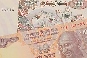 A orange ten rupee bill from India paired with a beige 200 Algerian dinar bank note.