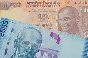 A orange ten rupee bill from India paired with a colorful two thousand colones bank note from Costa Rica.