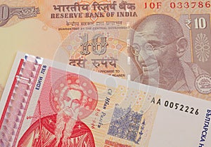 A orange ten rupee bill from India paired with a red and white one lev bank note from Bulgaria.