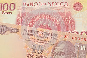 A orange ten rupee bill from India paired with a red and yellow one hundred peso bill from Mexico.