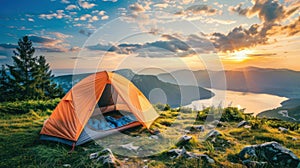 An orange tent is pitched up on the rocky summit of a mountain, overlooking a vast landscape below