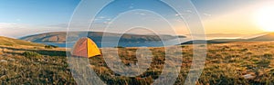 An orange tent stands in the middle of a vast grassy field, under a clear sky