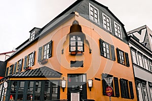 Orange, terracotta old house cafe in iceland reykyavik. Small balcony with flower pots