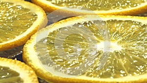 Orange thinly sliced lobules lies on a dark background, juicy, tasty citrus, sweet juice.