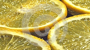 Orange thinly sliced lobules lies on a dark background, juicy, tasty citrus, sweet juice.