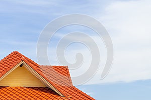 Orange tile roof with a blue sky background and clouds and copy space
