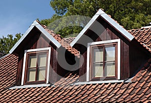 Orange tiled roof and garret windows in old house photo