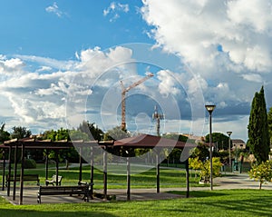 Orange tower crane against blue sky view from a city park