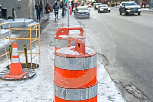 The orange traffic cone on the sidewalk in Montreal downtown