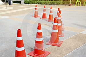 Orange traffic cones stand on concrete