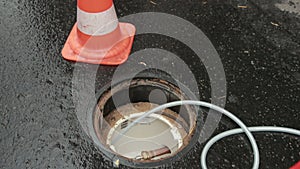 Orange Traffic Cones Standing In Row On Dark Asphalt. Open Communication Hatch.