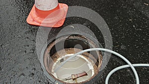 Orange Traffic Cones Standing In Row On Dark Asphalt. Open Communication Hatch.