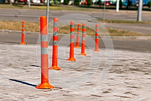 Orange traffic pillar on the road and on parking lane