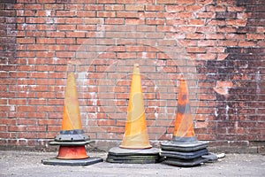 Orange traffic safety cones and red brick wall