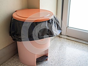 Orange trash is located in the corner of the room