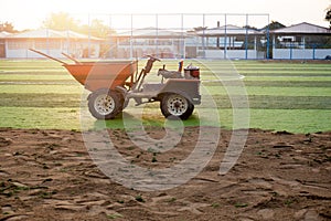 Orange truck with tools on artificial grass on soccer field