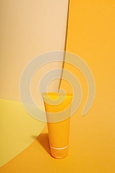 Orange tube of sunscreen on orange background. Sun Protection. Copy space