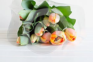 Orange tulip bouquet on table