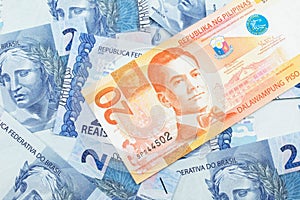 An orange twenty piso bank note from the Philippines with Mexican twenty peso bank notes close up in macro