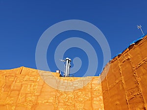 Orange urethane foam on the building, orange wall with blue sky in Spain