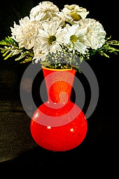Orange vase filled with white roses and dasies